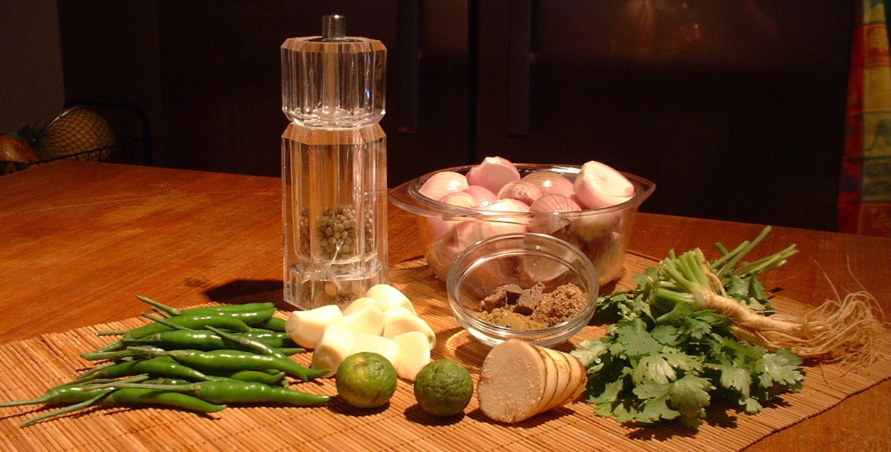 Chillies, lemongrass, galangal, lime, and shallots laid out for a curry paste